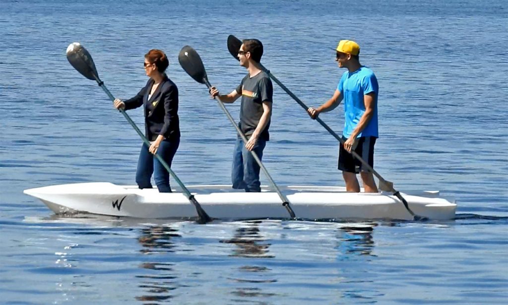 stand up paddling 3 paddlers on board a Wavewalk S4